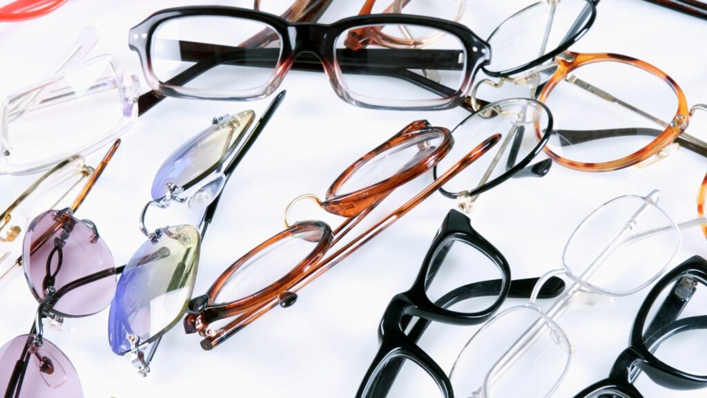 Multicolored eyeglasses Scattered on a white table